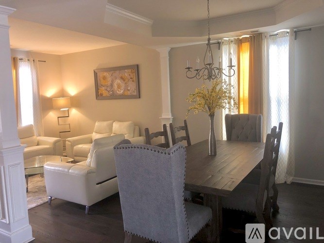 A dining room with a wooden table and chairs.