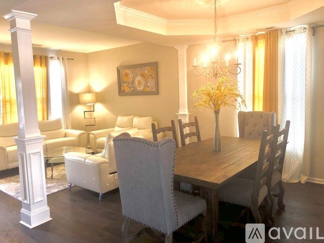 A well-lit dining room with a wooden table and chairs.