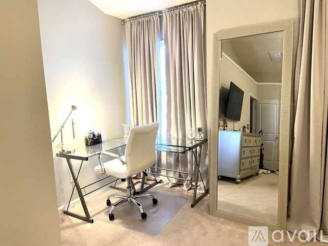 A room with a desk, chair, and a mirror.