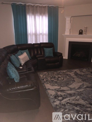 A living room with a brown couch and a fireplace.
