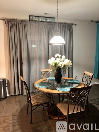 A dining room with a round table and chairs.