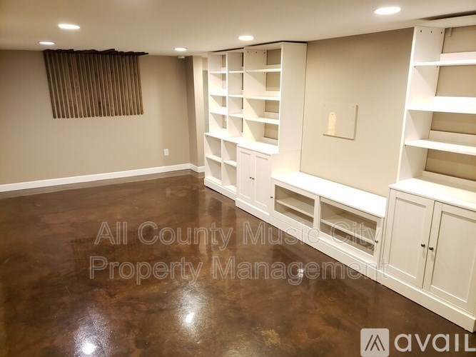 A room with white shelving units and a brown floor.
