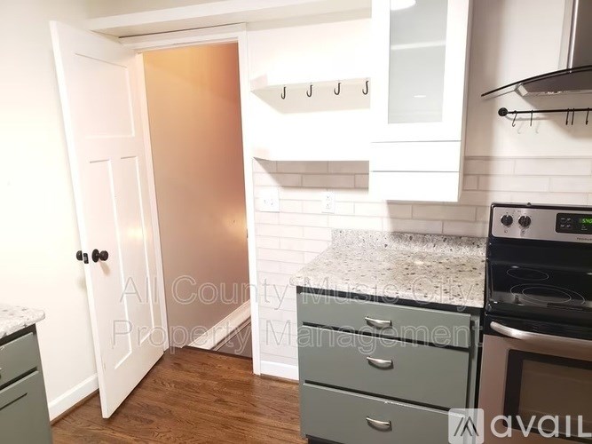 A kitchen with a white door, a counter, and a stove.