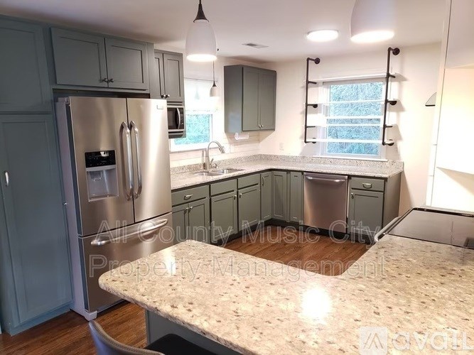 A kitchen with a granite countertop and stainless steel appliances.