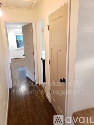 A hallway with a door on the right and a window in the distance.