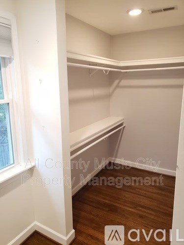 A room with a window and a wooden floor.