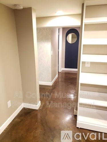 A hallway with a blue door and a white wall.