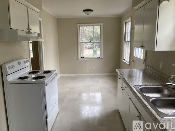 A kitchen with a white stove and a window.