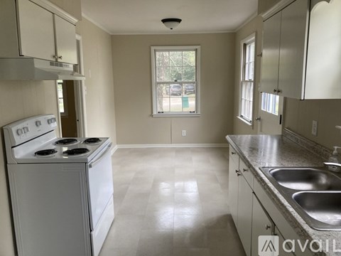 A kitchen with a white stove and a window.