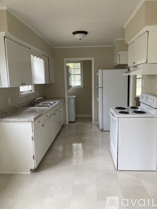 A kitchen with white appliances and cabinets.