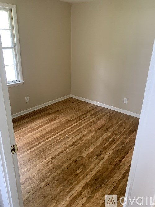 A room with wooden flooring and a window.