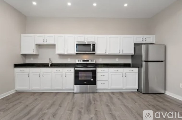 A kitchen with white cabinets and a stainless steel refrigerator.