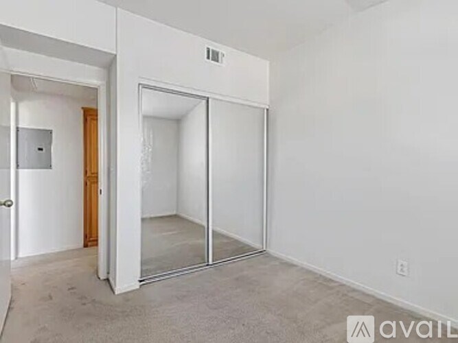 A white room with a door and a mirror.