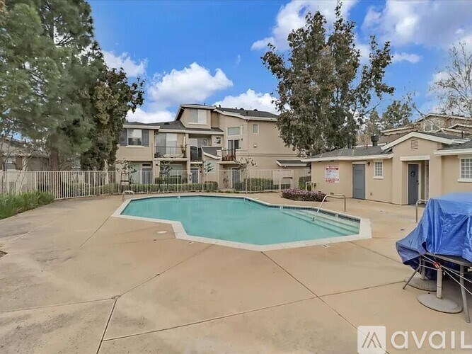 A swimming pool in a backyard surrounded by a fence.