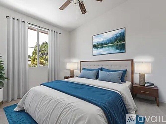 A bedroom with a large bed and a ceiling fan.