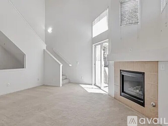 A modern living room with a fireplace and a staircase.