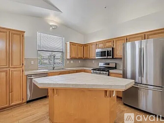 A kitchen with wooden cabinets and a marble countertop.