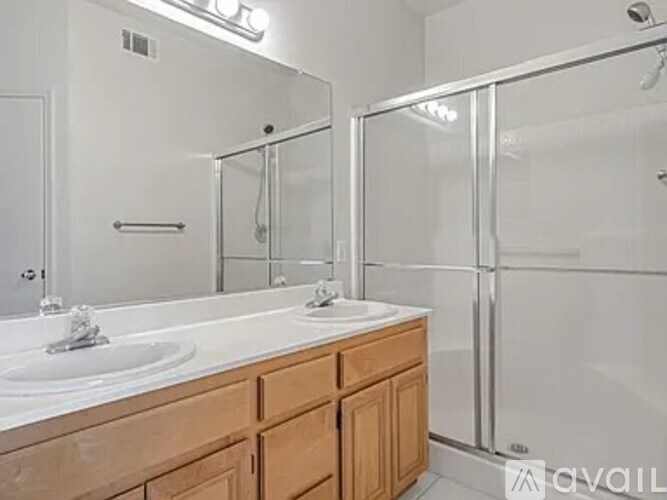 A bathroom with a white countertop and a walk-in shower.