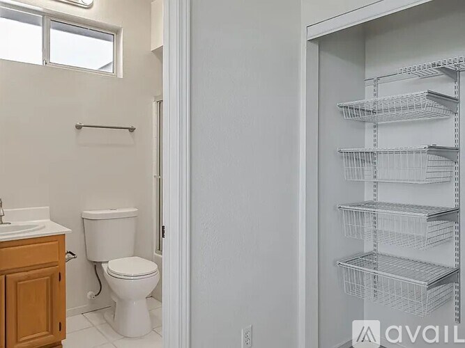 A white toilet sits in a bathroom next to a sink.