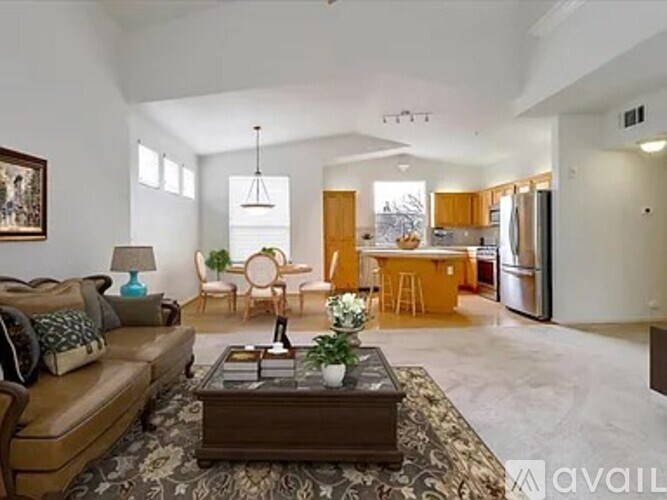 A living room with a brown sofa and a coffee table in the center.
