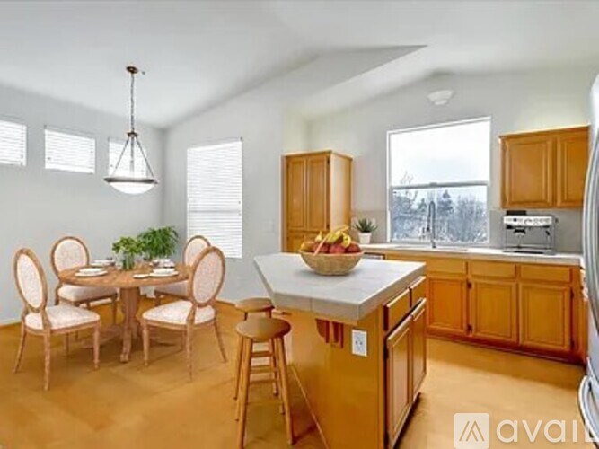 A kitchen with wooden cabinets and a dining table with chairs.
