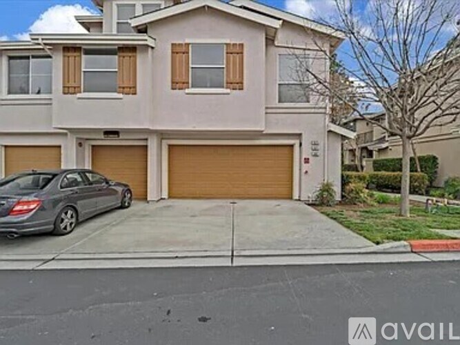 A two-story house with a garage and a car parked in front.