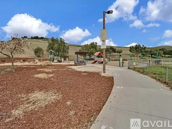 A park with a walking path and a signpost.