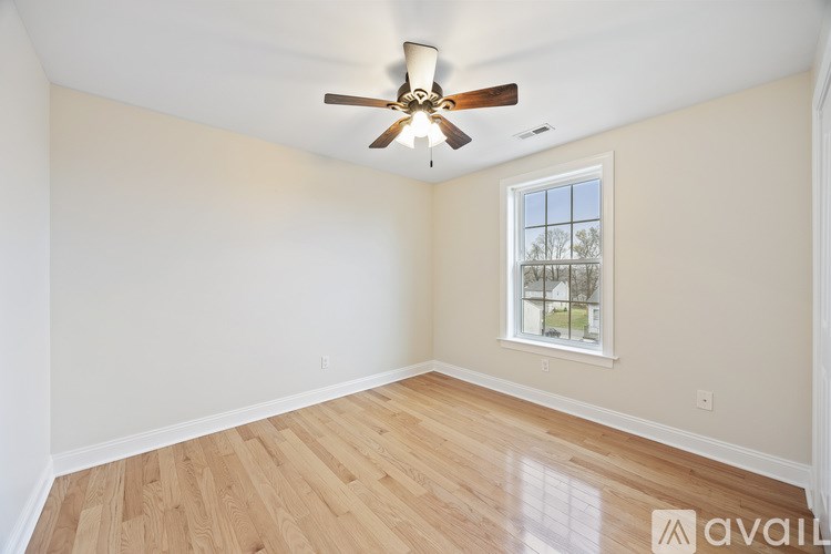 A room with a ceiling fan and a window.
