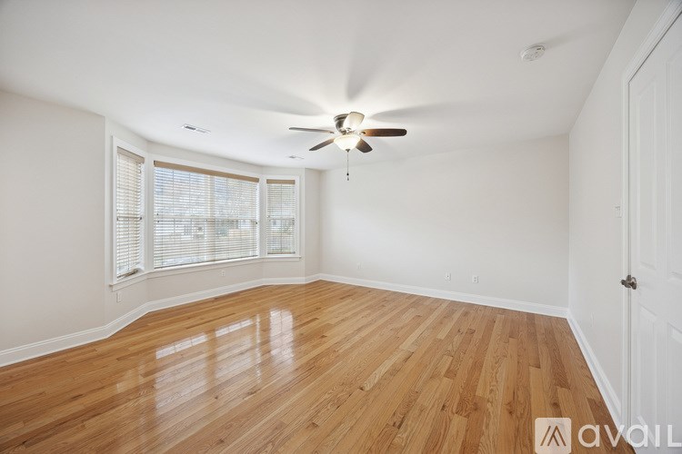 A room with wooden flooring and a ceiling fan.