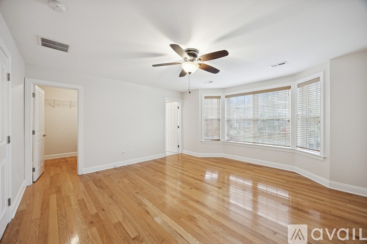 A room with wooden floors and a ceiling fan.