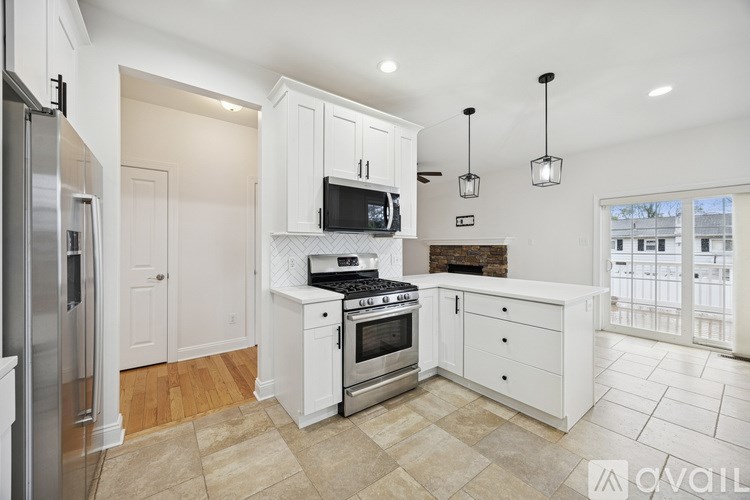 A kitchen with white cabinets and a tiled backsplash.