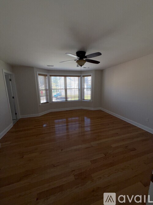 A room with wooden floors and a ceiling fan.