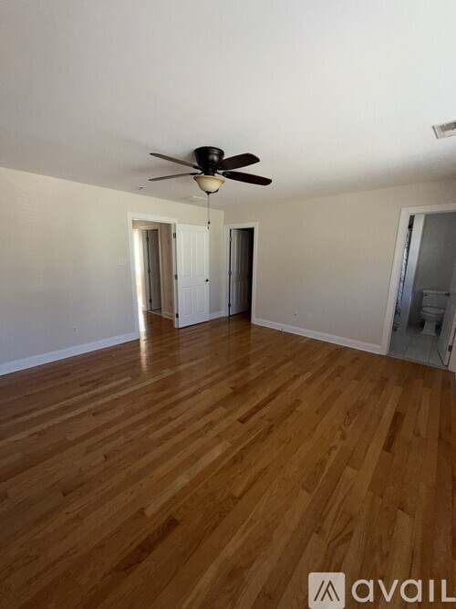 A room with wooden flooring and a ceiling fan.