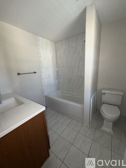A white toilet sits next to a bathtub in a bathroom.
