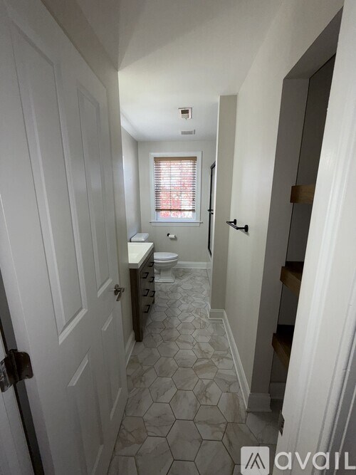A hallway with a tiled floor and white walls.