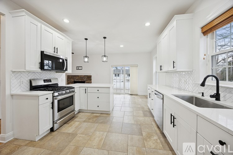 A spacious room with wooden flooring and white walls.