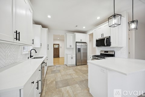 A kitchen with white cabinets and a tiled backsplash.