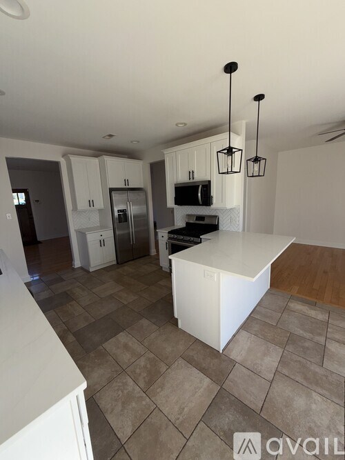 A kitchen with white cabinets and a stainless steel sink.