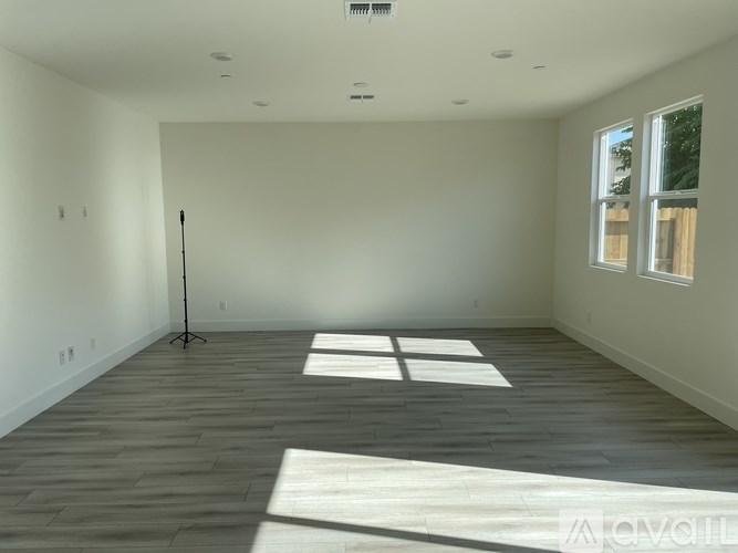 A room with wooden flooring and a large window.