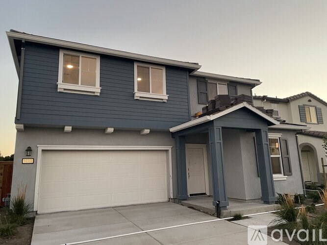 A two-story house with a garage is available for sale.