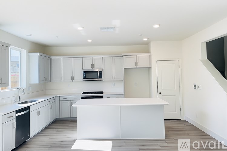 A modern kitchen with white cabinets and appliances.