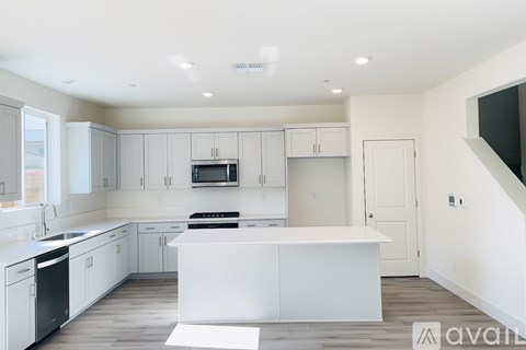 A modern kitchen with white cabinets and appliances.