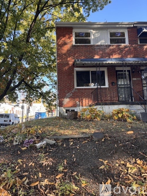 A red brick house with a white door and windows.