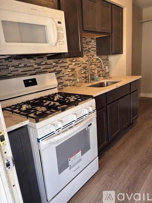 A modern kitchen with a white stove top oven and microwave above it.