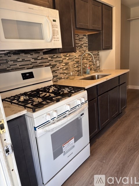 A modern kitchen with a white stove top oven and microwave above it.
