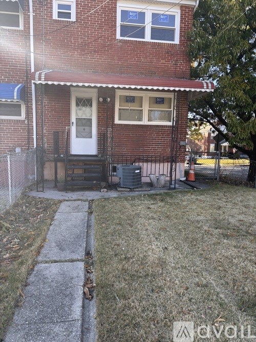 A red brick house with a white door and a small porch.