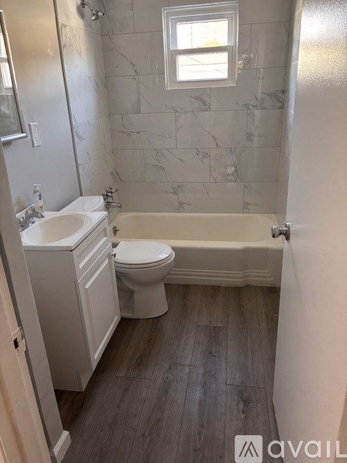 A bathroom with a tub, toilet, and sink.