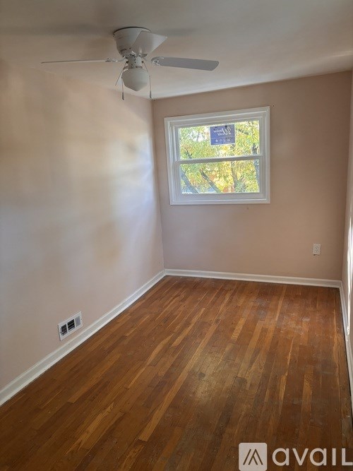 A room with a window and a fan on the ceiling.