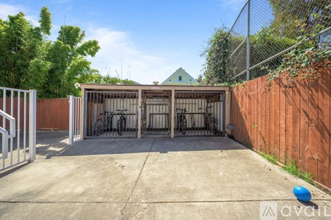 A backyard with a fence, a gate, and a bicycle.