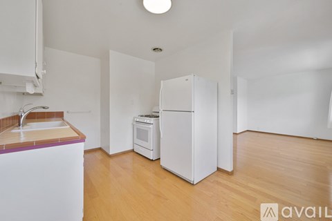 A kitchen with a sink, a stove, and a refrigerator.